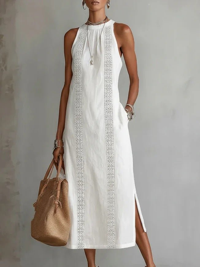 White sleeveless midi dress with lace trim, side slit, and halter neckline, paired with woven tote bag