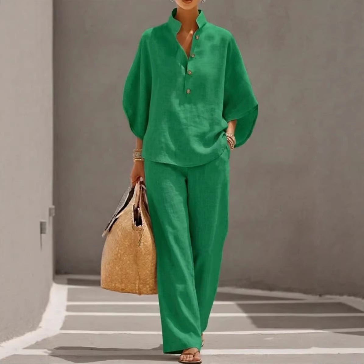 Woman in green linen matching set with wide sleeves and pants, carrying woven tote bag