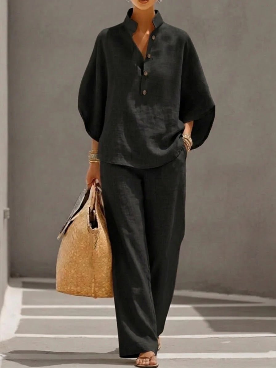 Woman in black linen shirt and wide-leg pants with straw tote bag, casual summer outfit